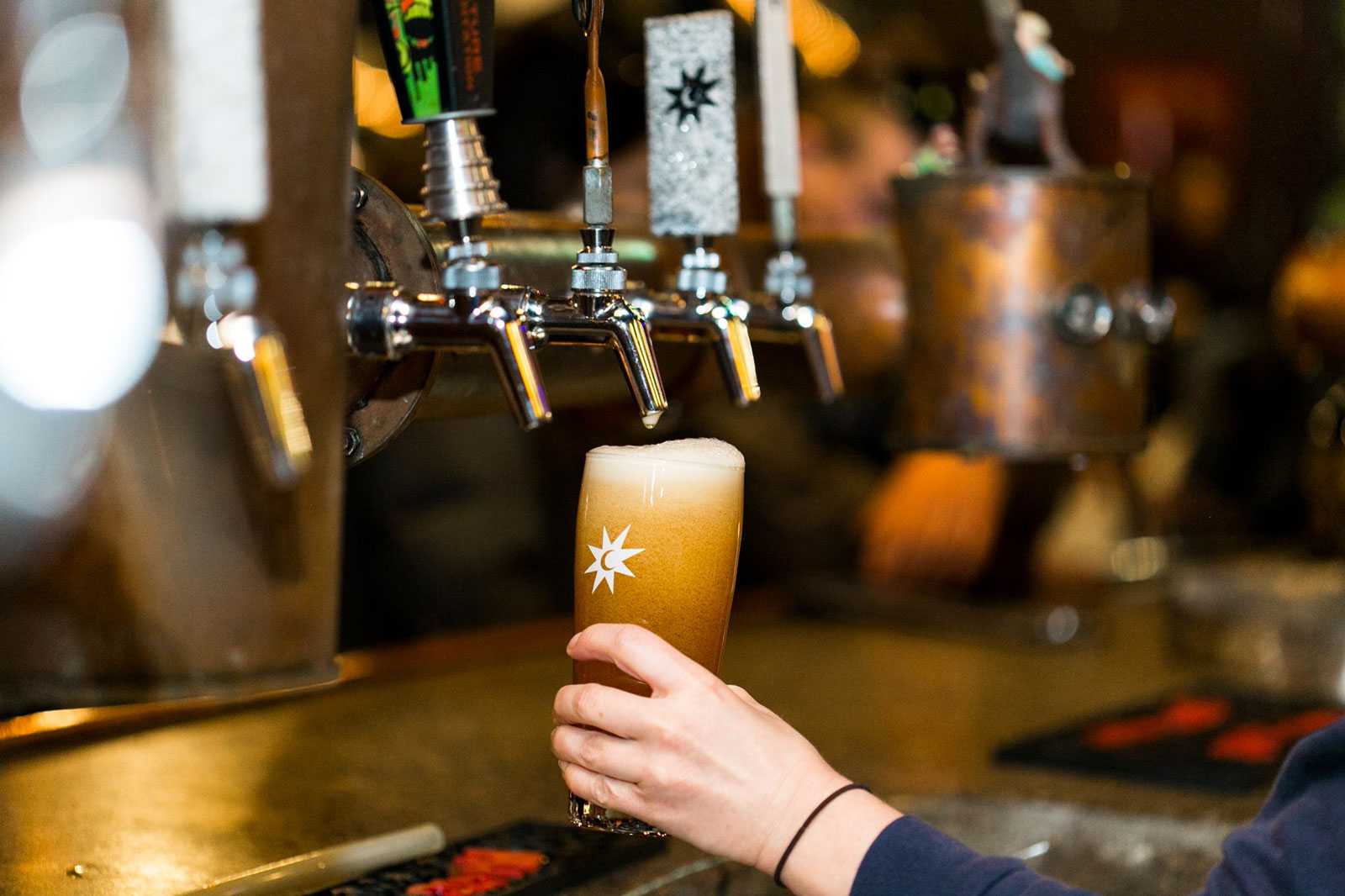 A glass of Magic Hit being filled at a beer tap