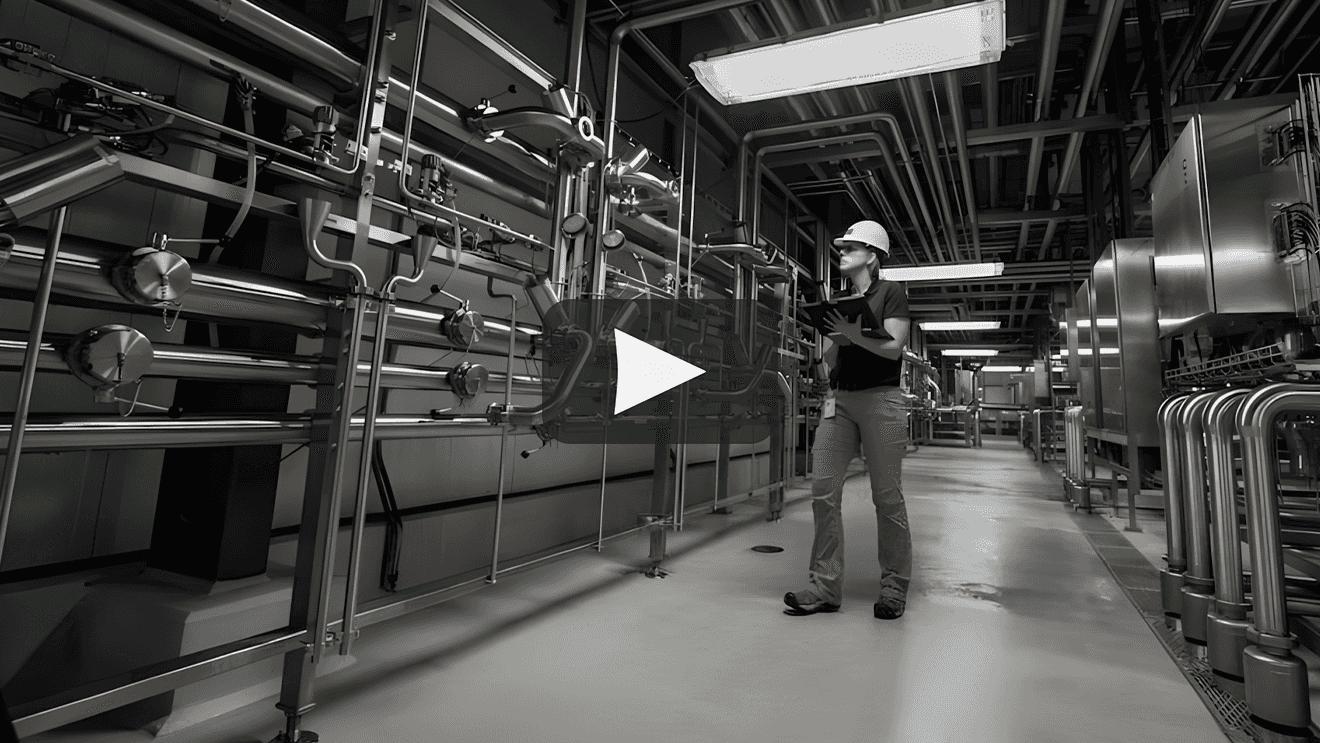 A packaging operator inspects a glass bottle on a production line